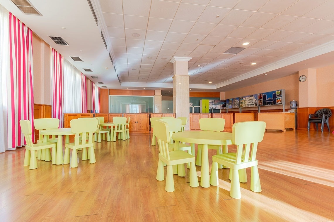 una habitación llena de mesas y sillas verdes