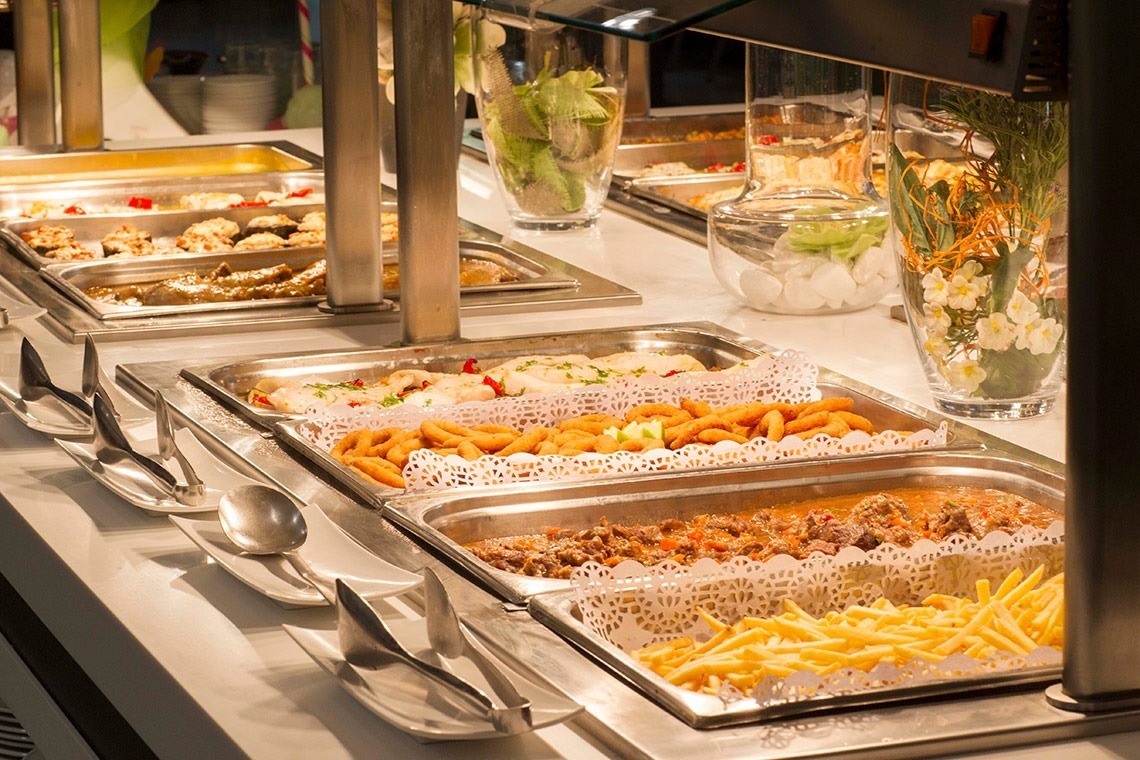 un buffet lleno de comida incluyendo papas fritas y carne