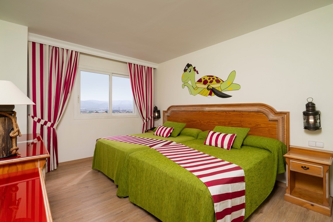 una habitación con dos camas y una tortuga pintada en la pared