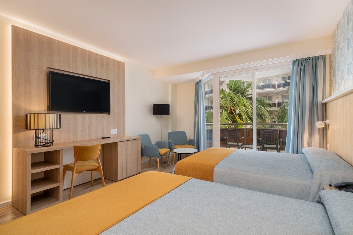 una habitación de hotel con dos camas y una televisión