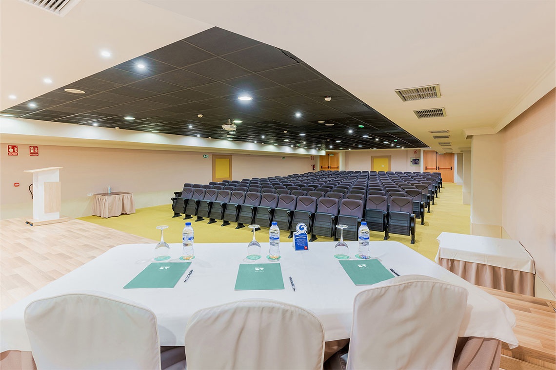 Peniscola Plaza Suites, sala de conferencias con asientos y mesa de presentación.
