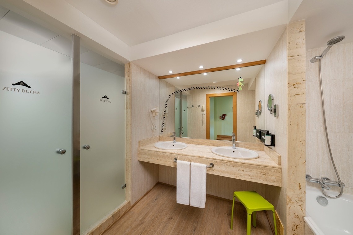 un baño con dos lavabos y una ducha con la palabra zetty ducha