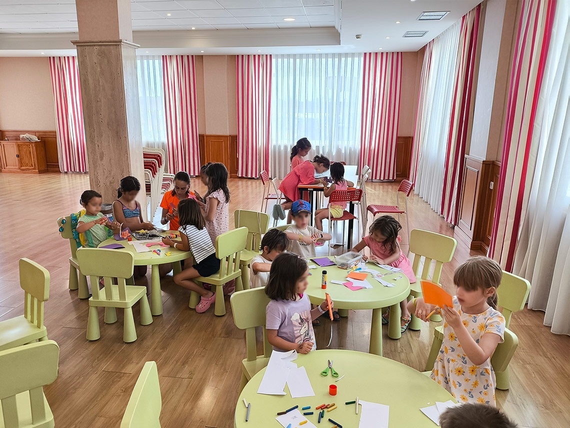 un grupo de niños están sentados en mesas en una habitación