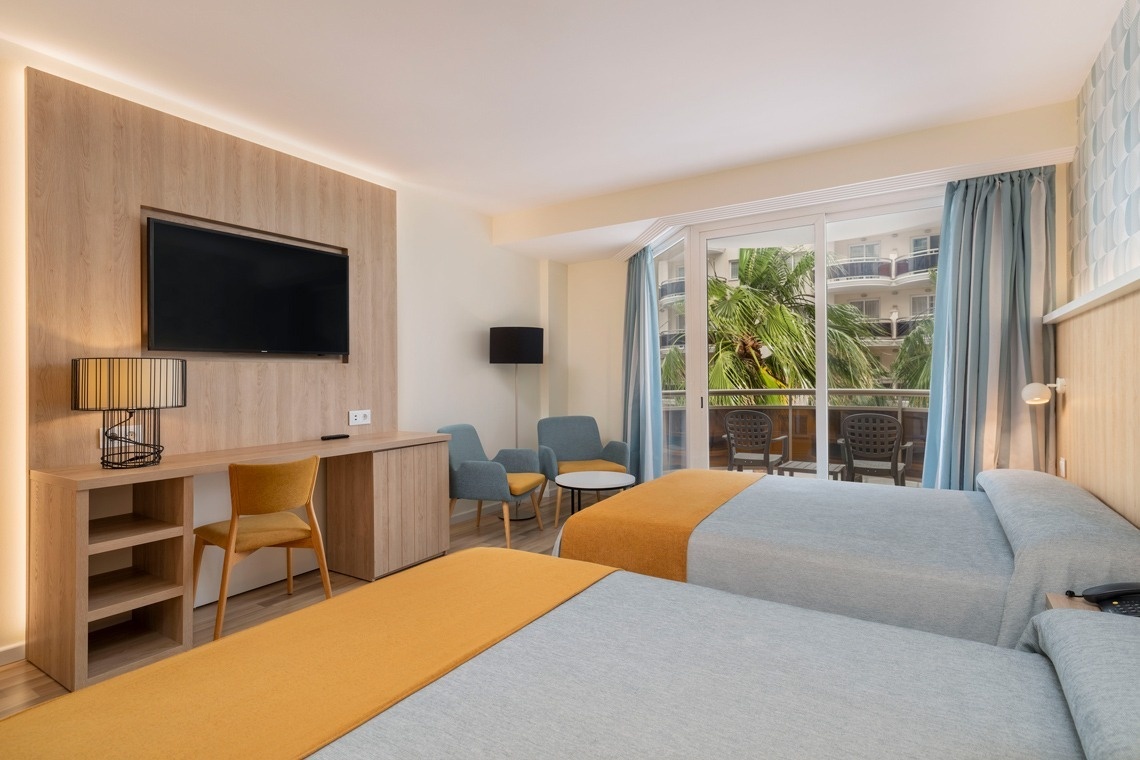 una habitación de hotel con dos camas y una mesa