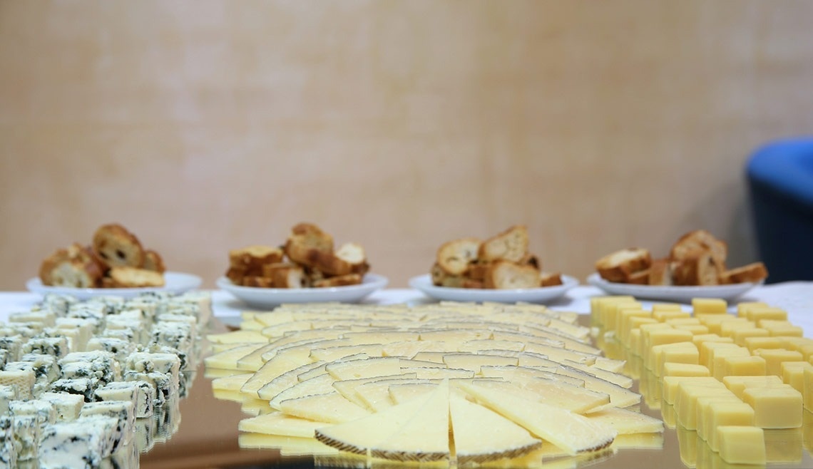 una variedad de quesos y pan están sobre una mesa