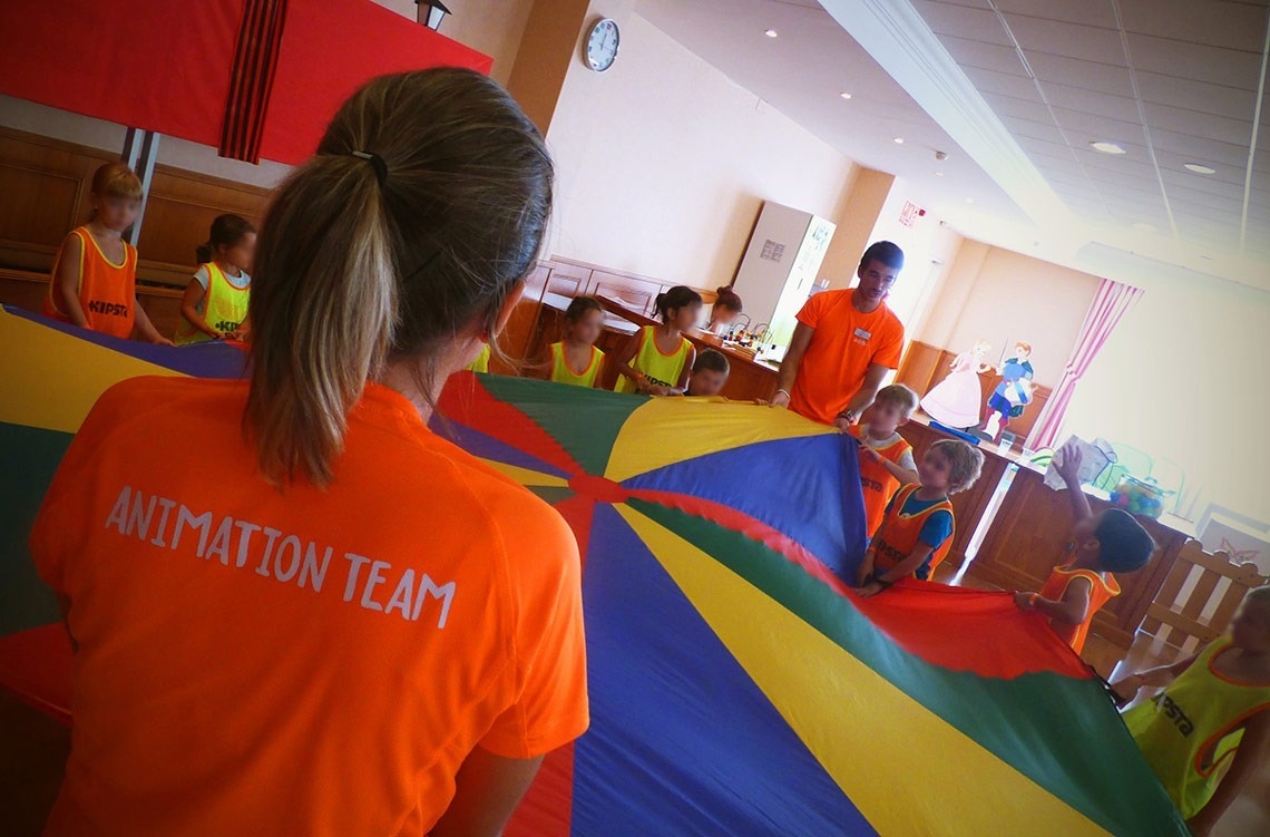 una mujer con una camisa naranja con el equipo de animación en la espalda