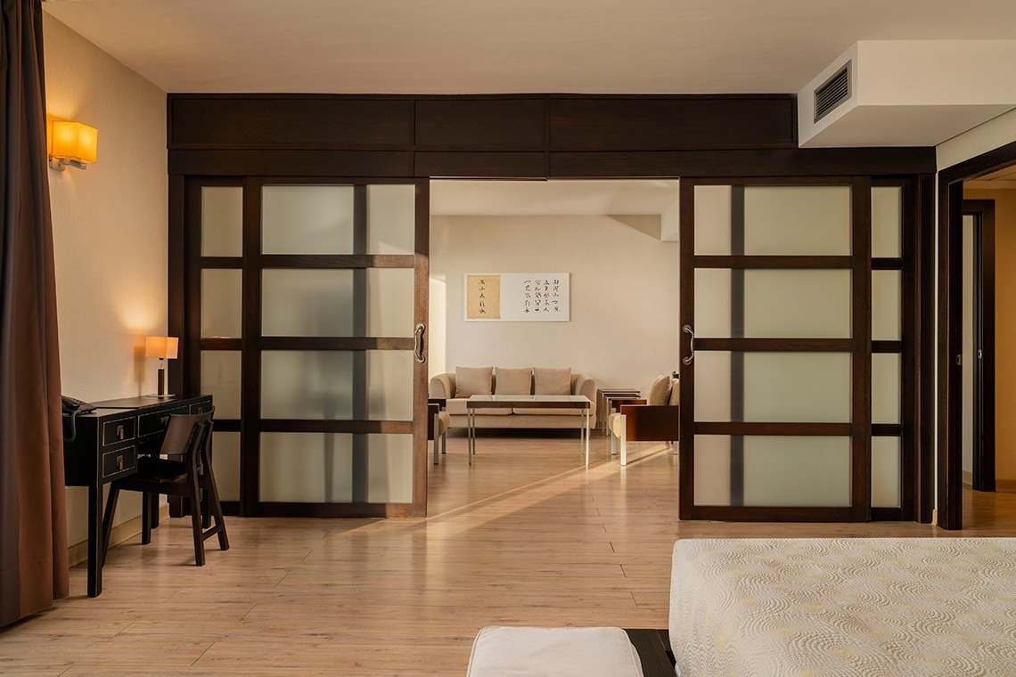 una habitación con puertas corredizas de vidrio que separan el dormitorio de la sala de estar