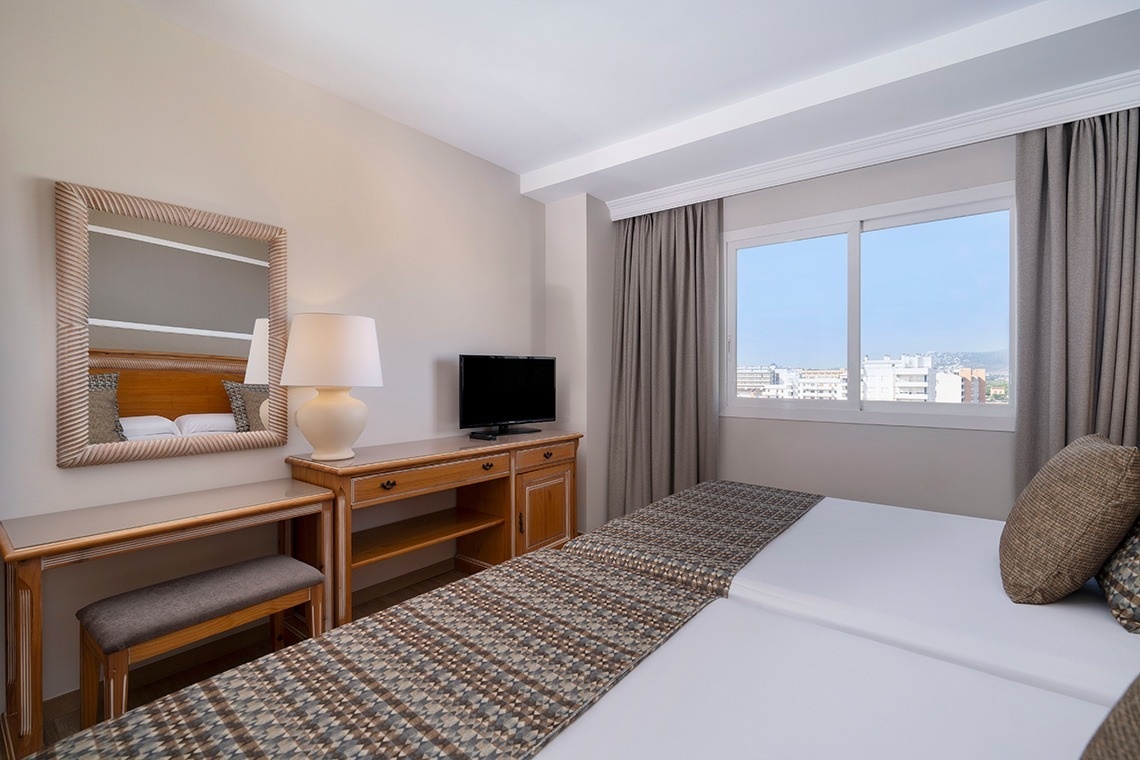 una habitación con dos camas , un escritorio y una televisión