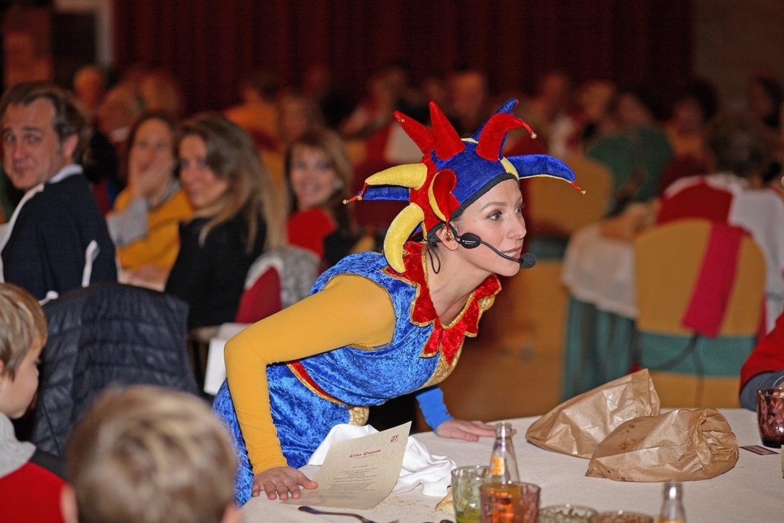 una mujer con un disfraz de payaso está sentada en una mesa