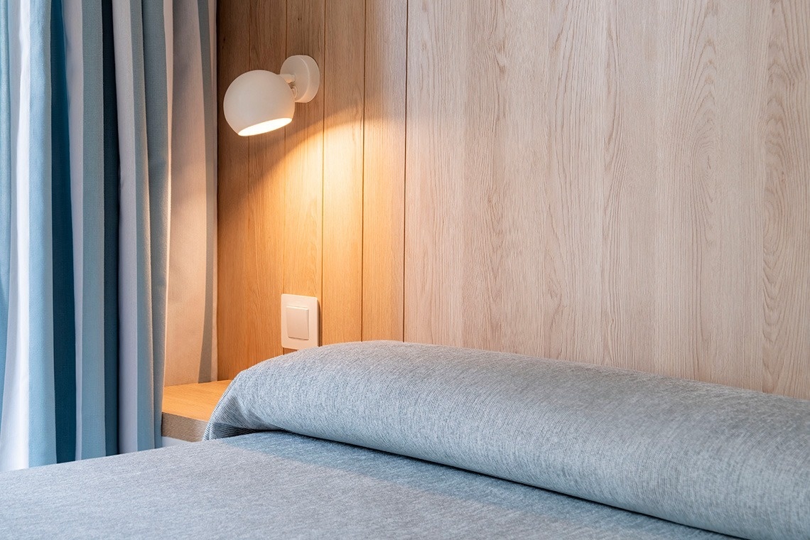 una habitación con una cama y una lámpara en la pared