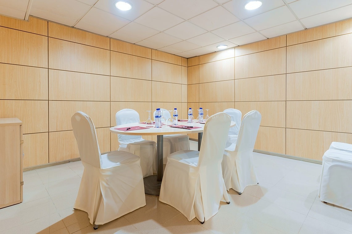 una habitación con una mesa y sillas y botellas de agua