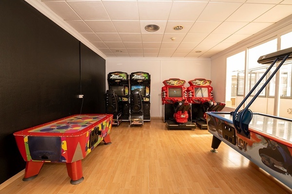 una sala de juegos con juegos de arcade y una mesa de baile