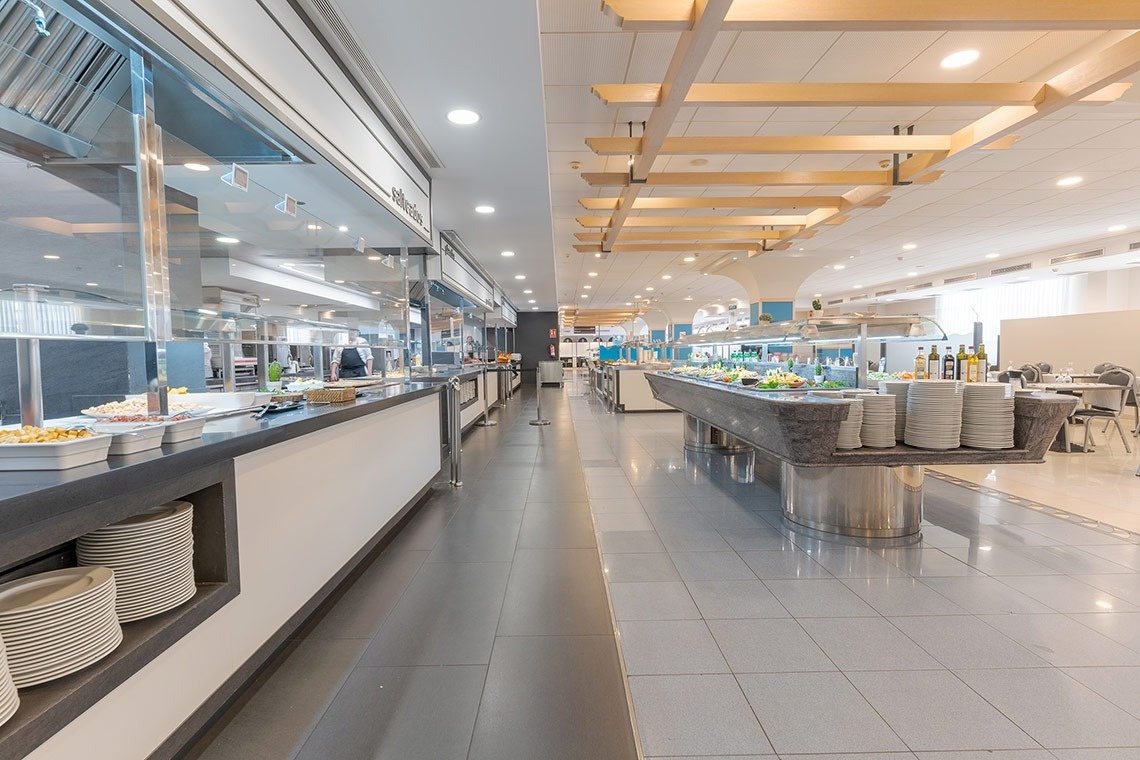 un buffet en un restaurante con platos blancos en la mesa