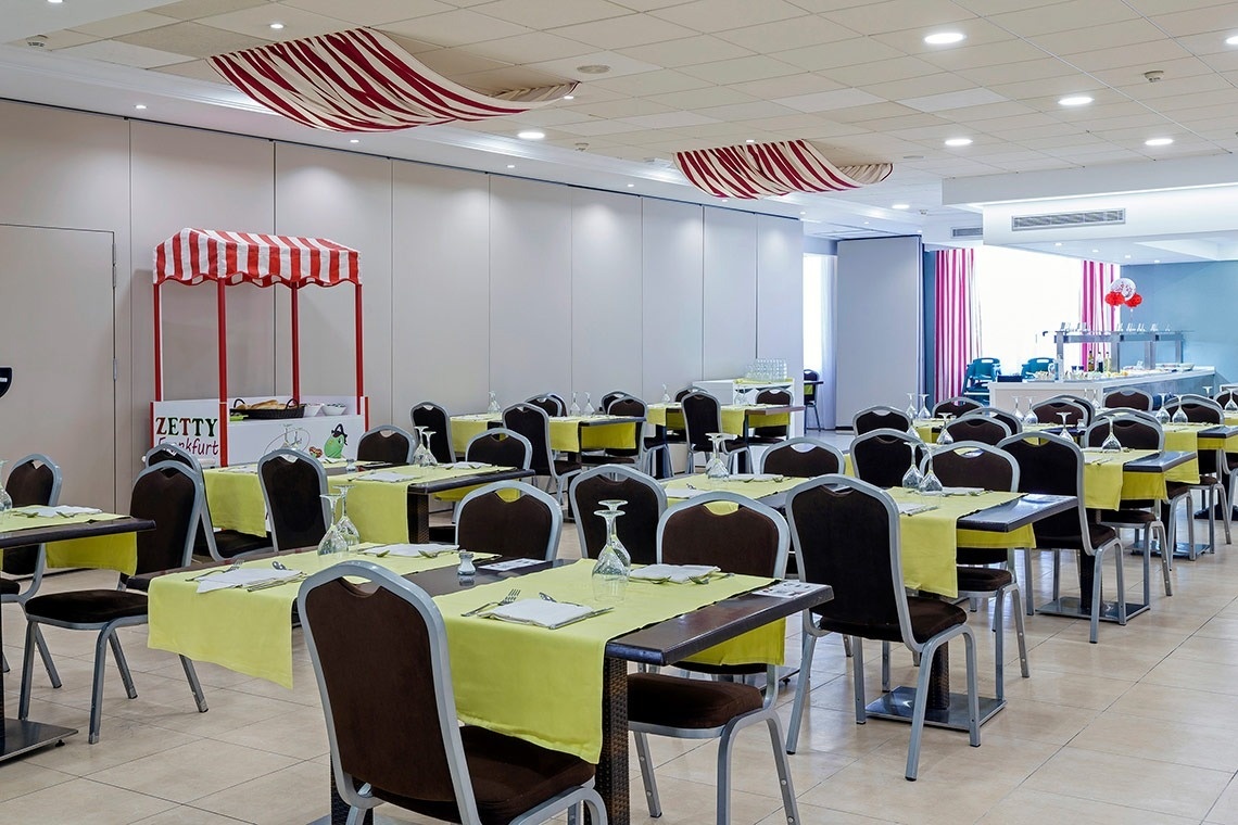 un restaurante con mesas y sillas y un puesto de zumo de limón