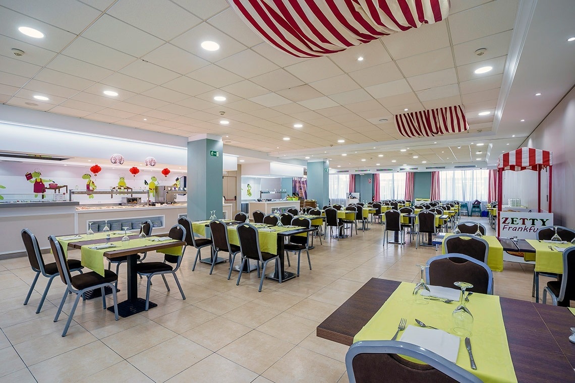 un comedor lleno de mesas y sillas con una carpa roja y blanca que dice zetty franky