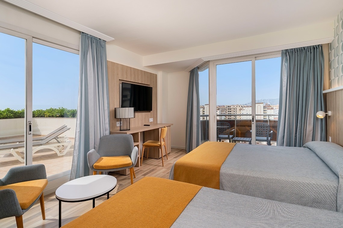 una habitación de hotel con dos camas y una televisión