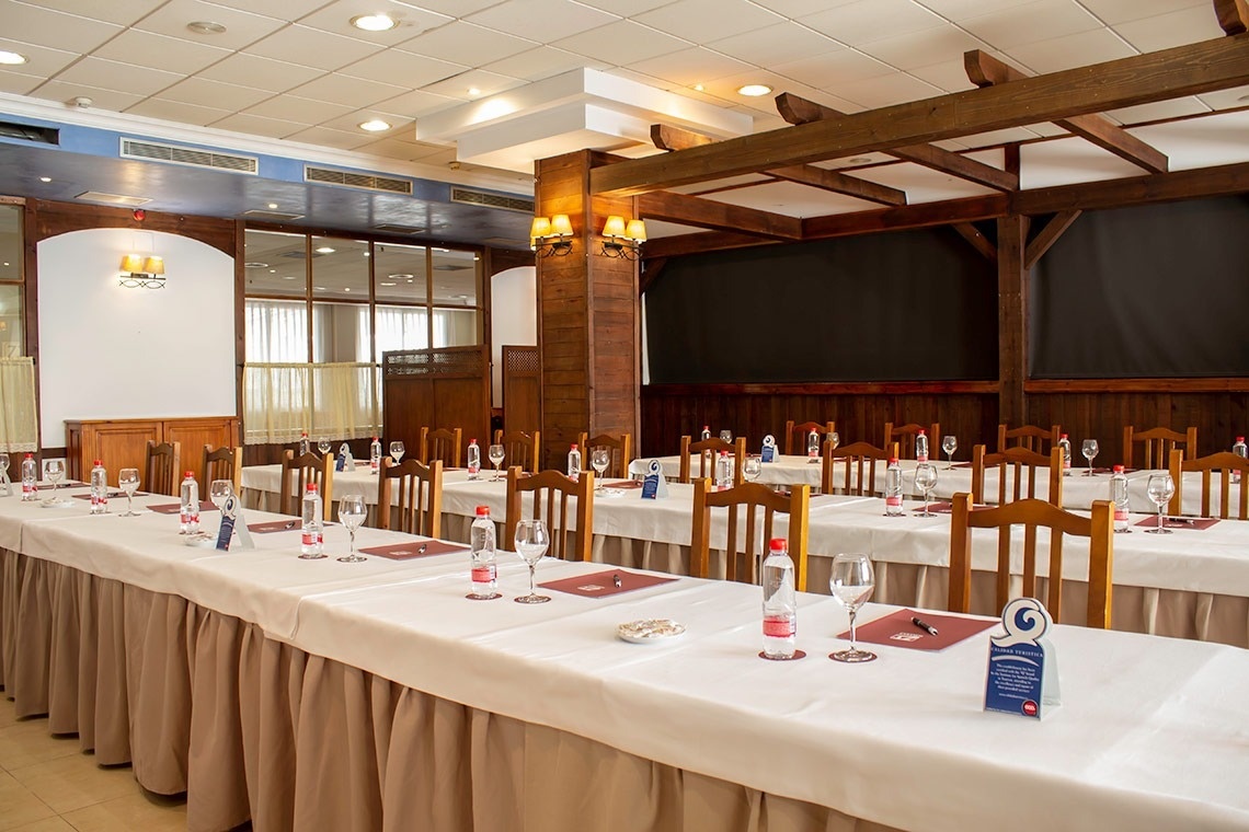 una sala de conferencias con mesas largas y sillas