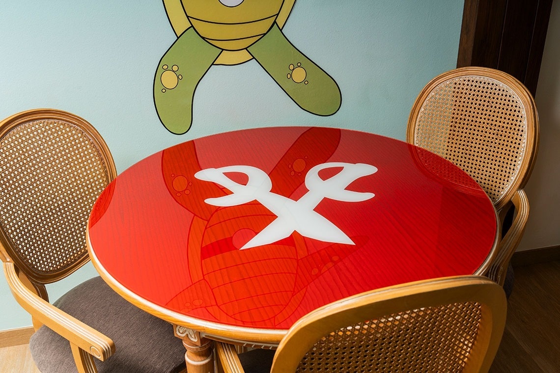 una mesa roja con un par de tijeras en la parte superior