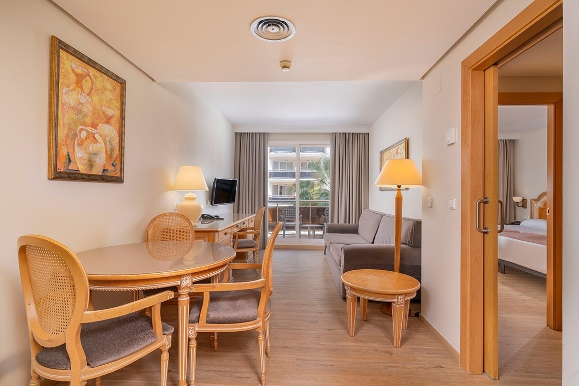 una habitación con una mesa y sillas y una pintura en la pared