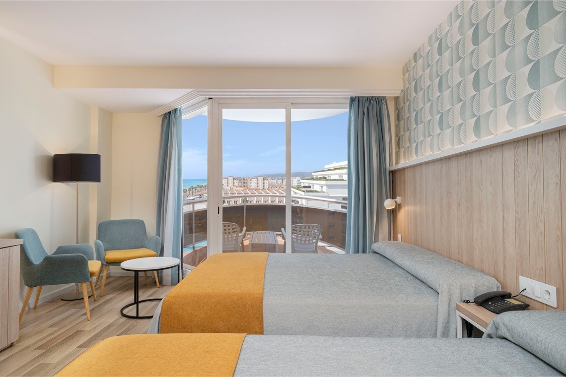 una habitación de hotel con dos camas y una mesa