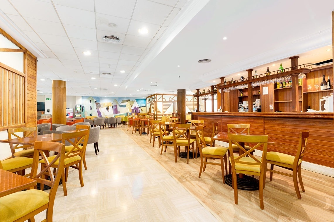 un restaurante lleno de mesas y sillas con una vista al océano