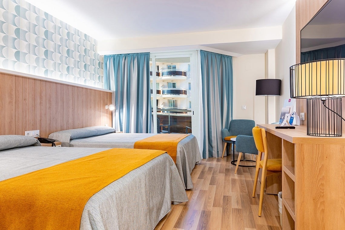 una habitación de hotel con dos camas y una mesa