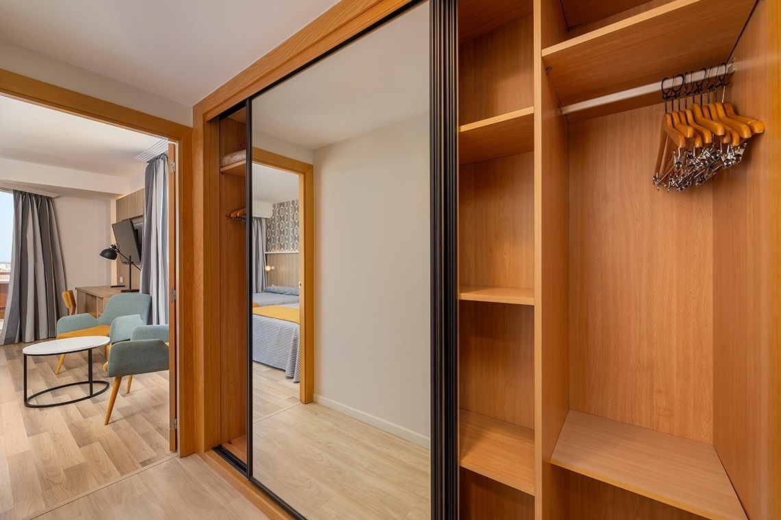 un armario de madera con perchas colgando de él