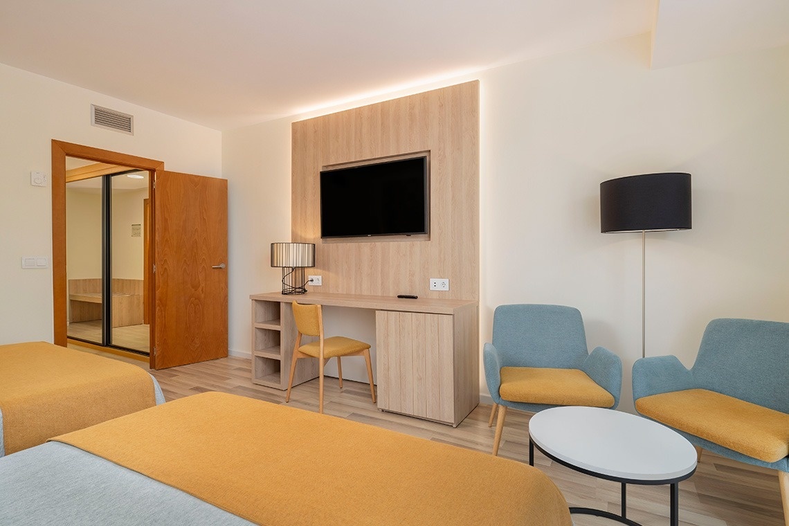 una habitación de hotel con dos camas y una televisión