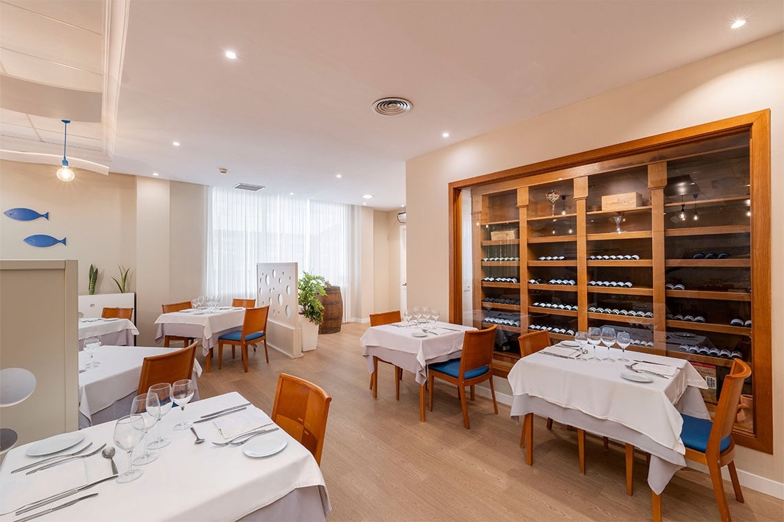 Restaurante ZT: Peniscola Plaza Suites con mesas puestas, acuario y decoración marina.