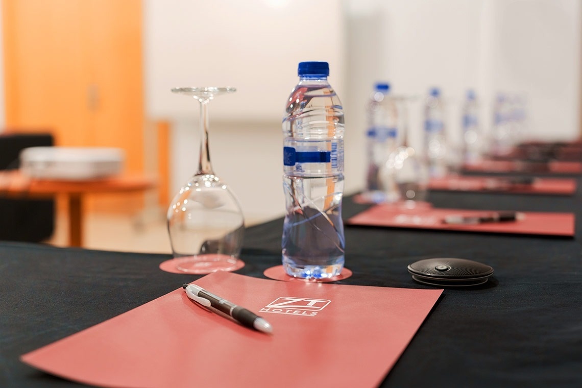 una mesa con una botella de agua y un portapapeles que dice zt hotel