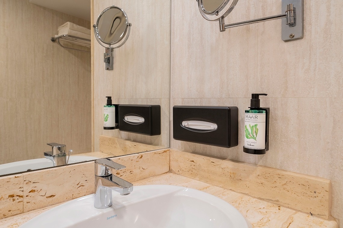 un baño con un lavabo y un dispensador de mar