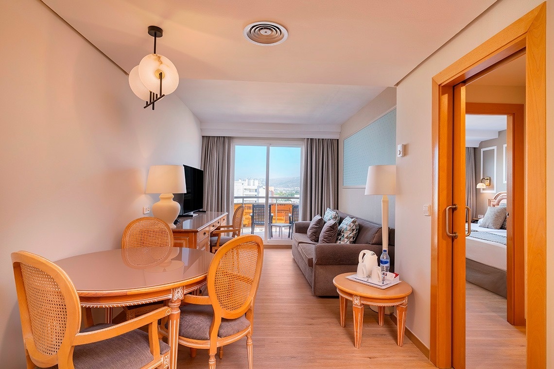 una habitación de hotel con una mesa y sillas y una televisión