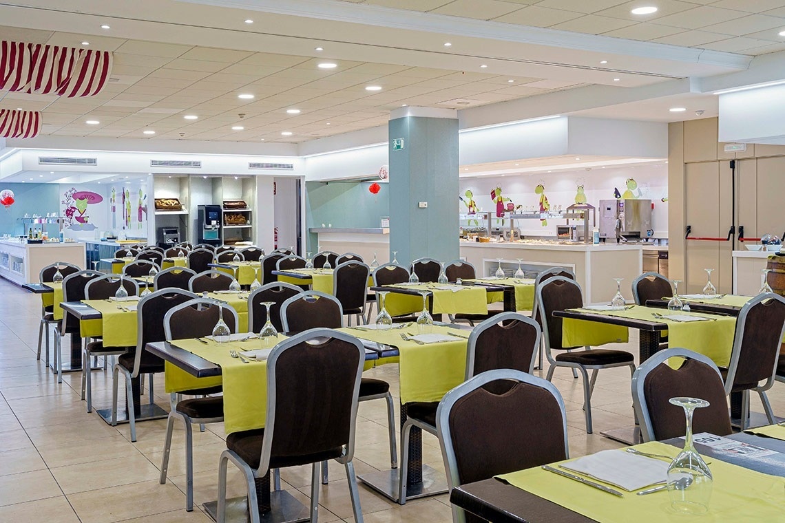 un restaurante lleno de mesas y sillas con mantel amarillo