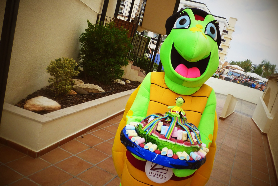 una persona sostiene un cóctel frente a una piscina infinita
