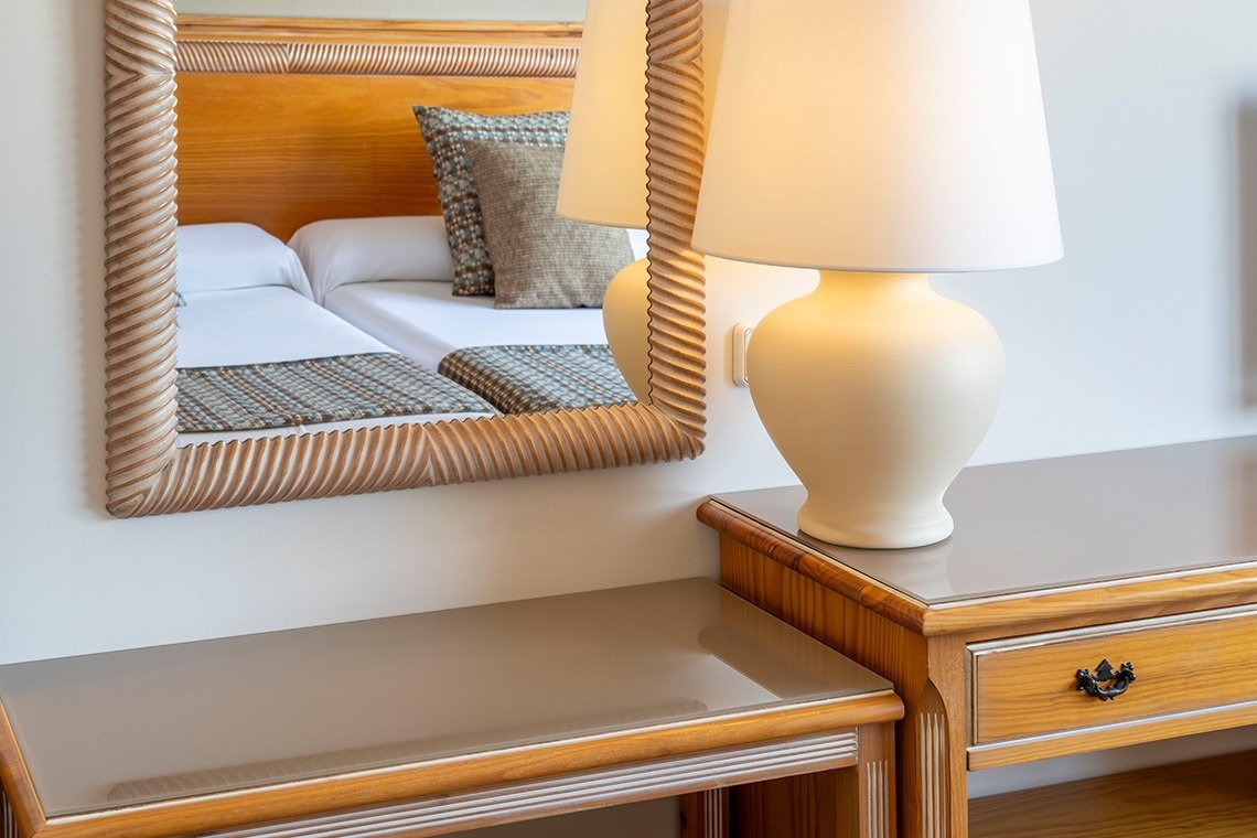 una mesa de madera con dos lámparas y un espejo