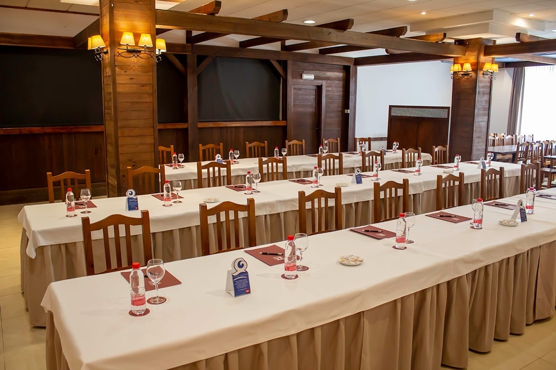 una habitación llena de mesas y sillas con botellas de agua y copas