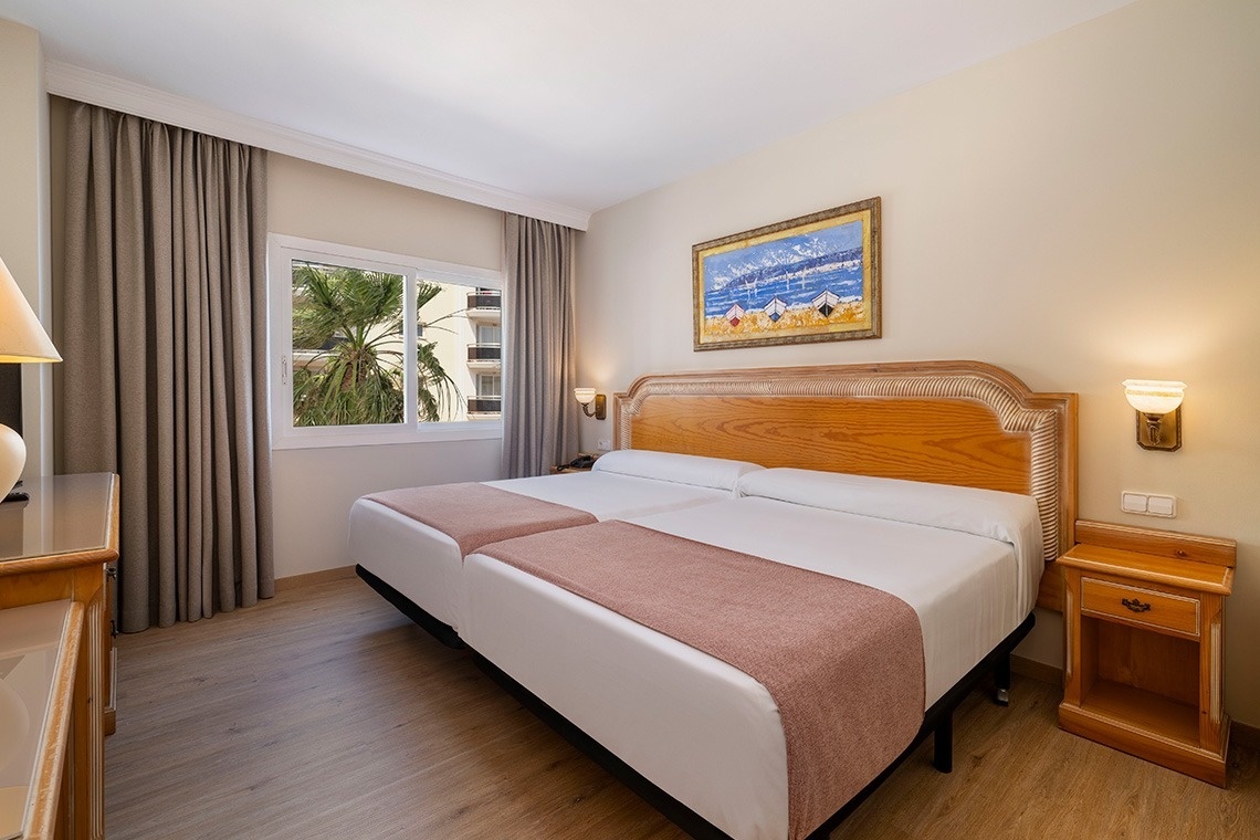 una habitación de hotel con dos camas y una pintura en la pared