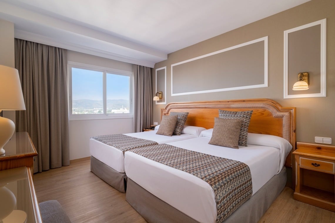 una habitación de hotel con dos camas y una mesa