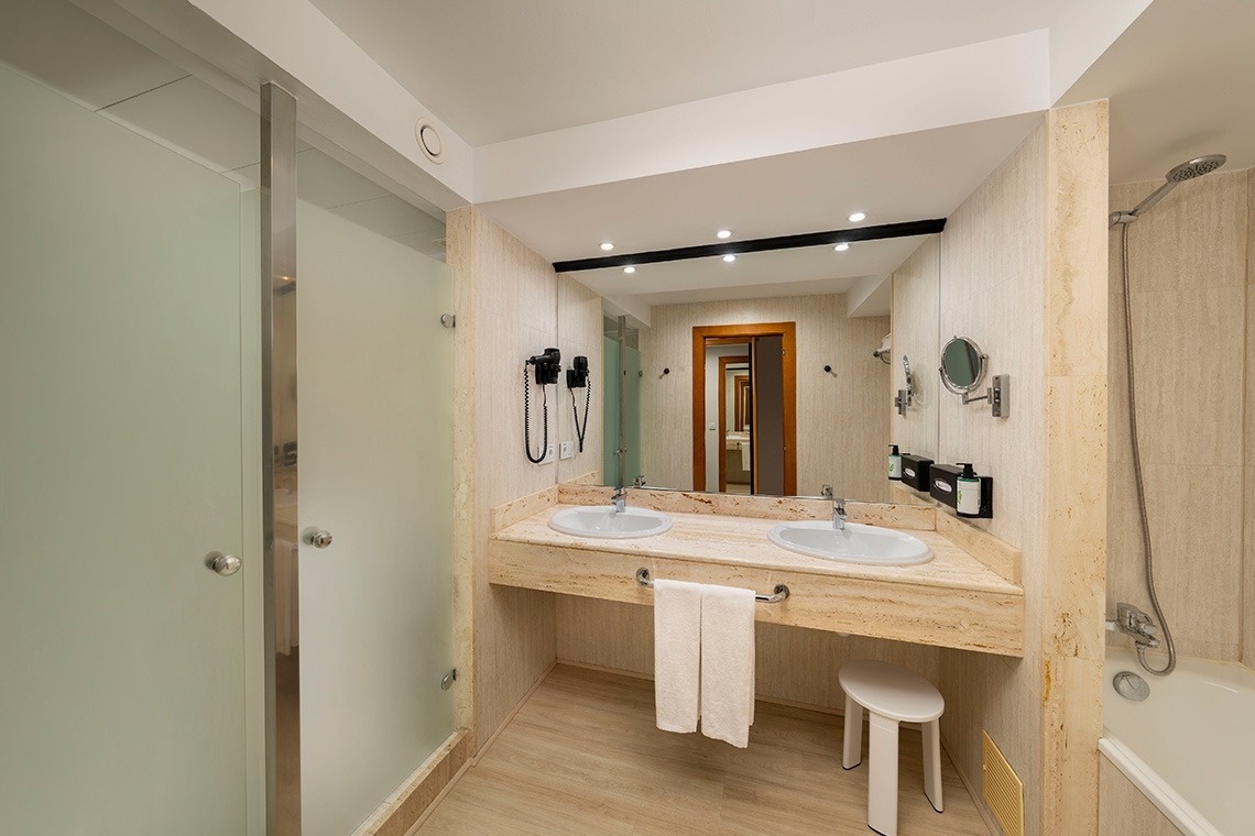 un baño con dos lavabos y una bañera