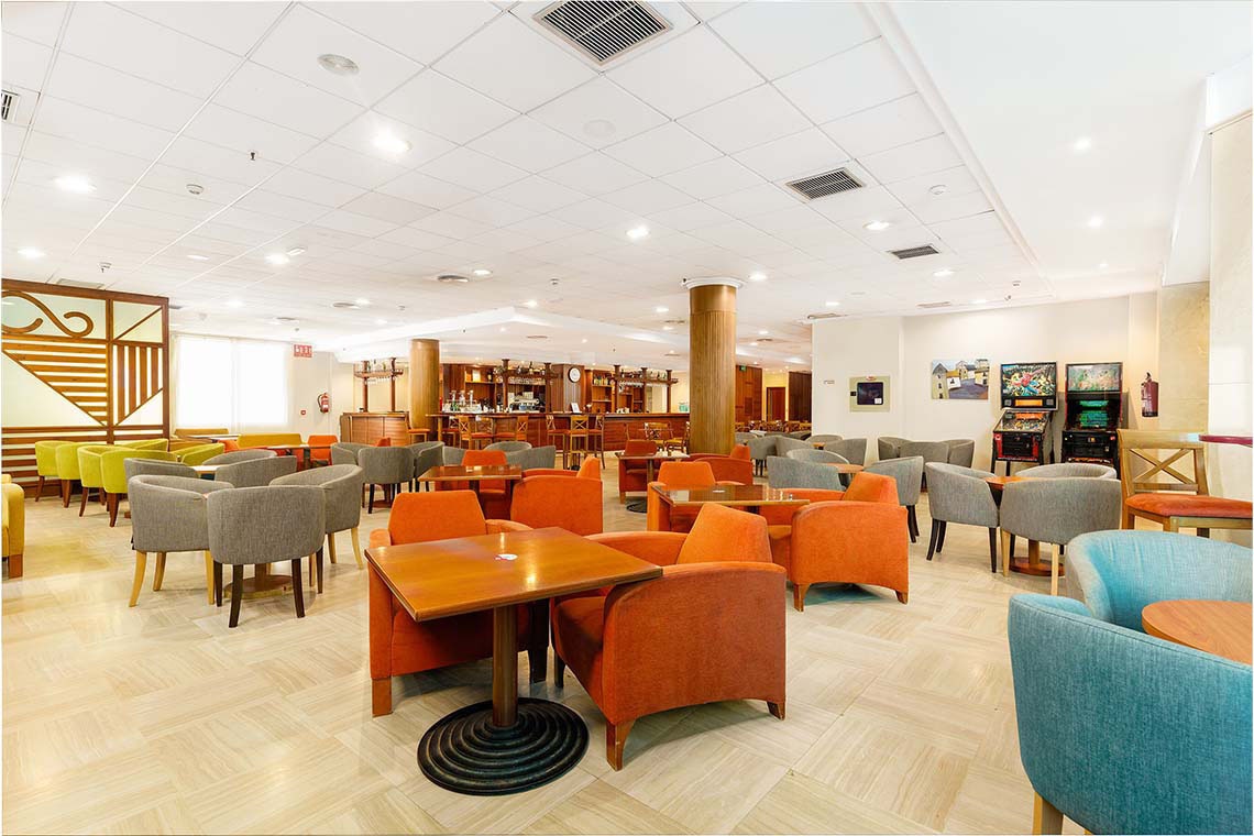 Bar y comedor de ZT: Peniscola Plaza Suites. Mesas, sillas y mural.