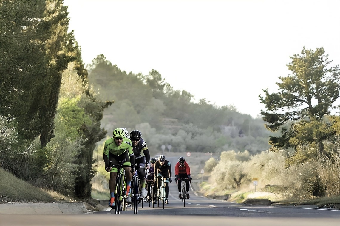 un adorno rojo colgando de una rama de un árbol de navidad cubierto de nieve