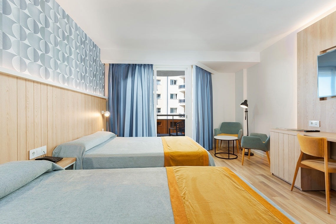 una habitación de hotel con dos camas y una televisión