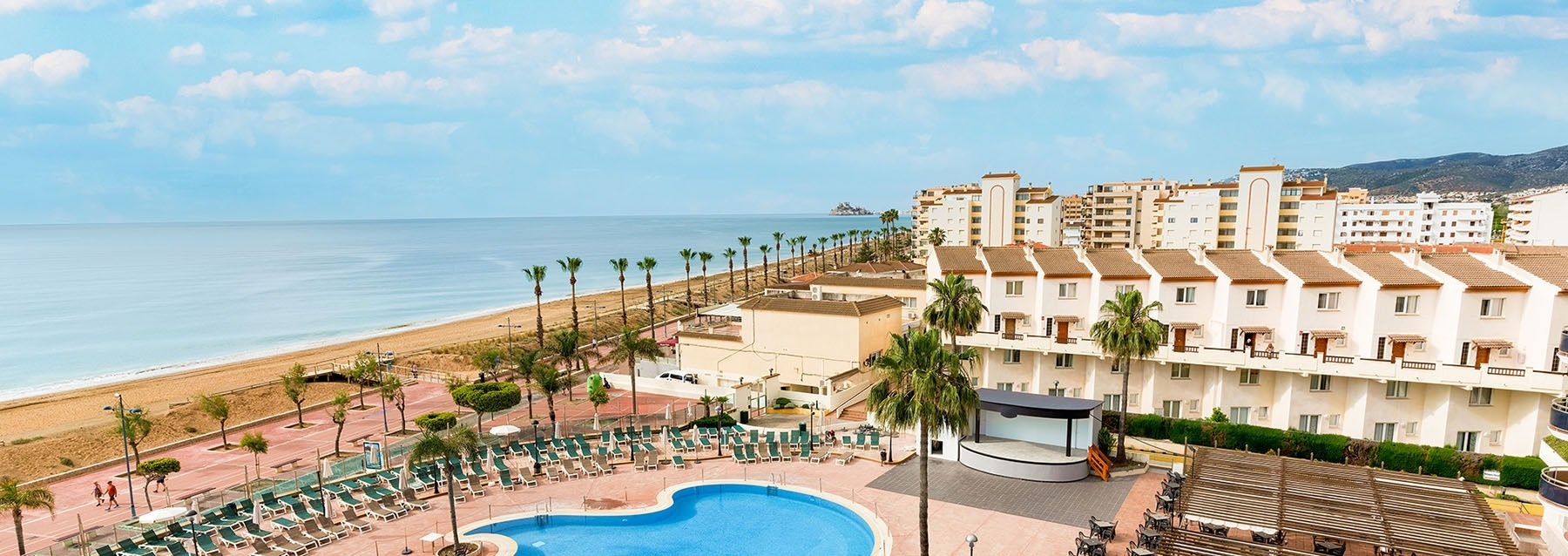 un patio con muebles y sombrillas y un techo camuflado