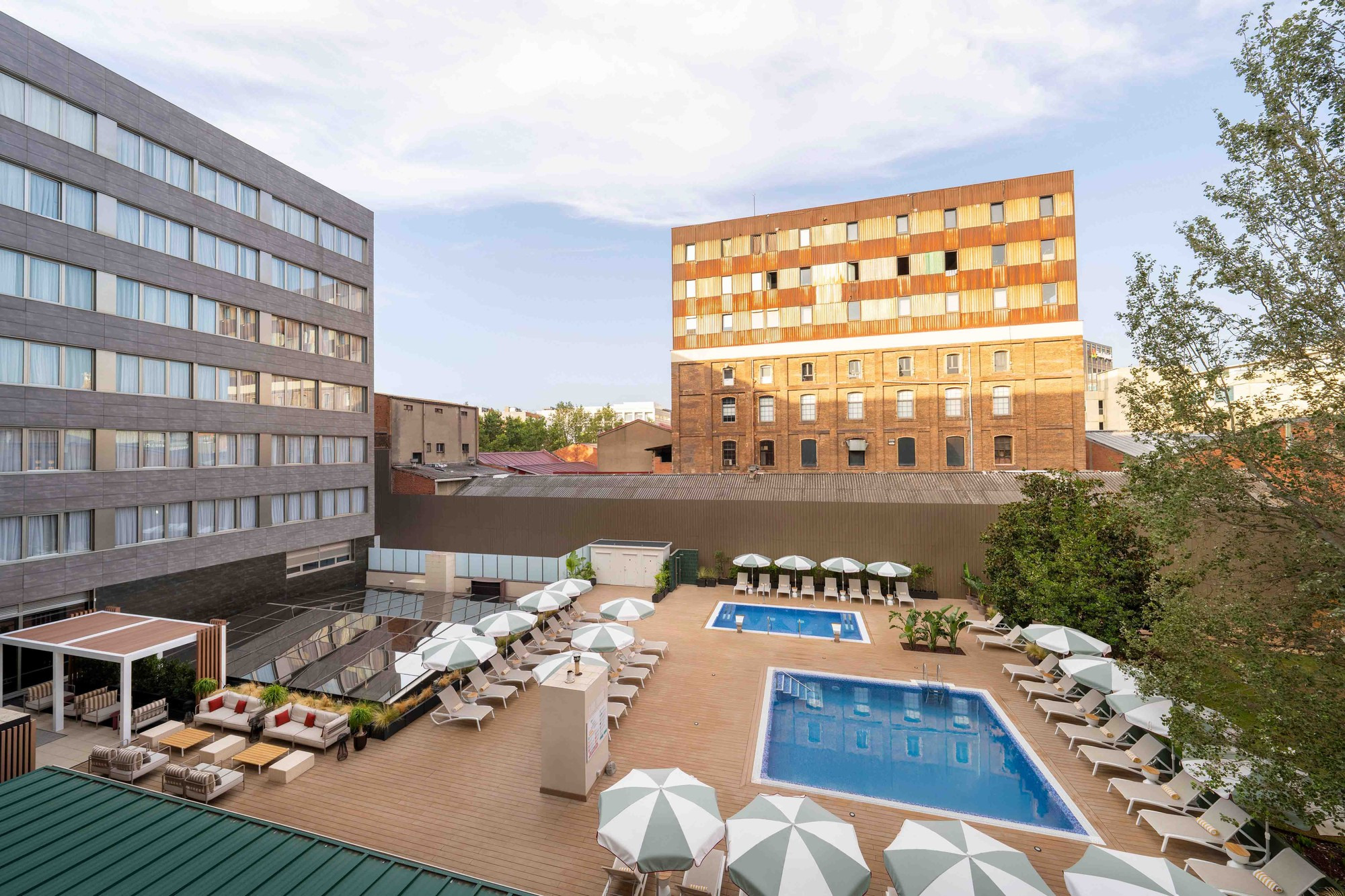 Piscina y área de descanso en la terraza del hotel, con tumbonas y sombrillas, en ZT: Villa Olímpica.
