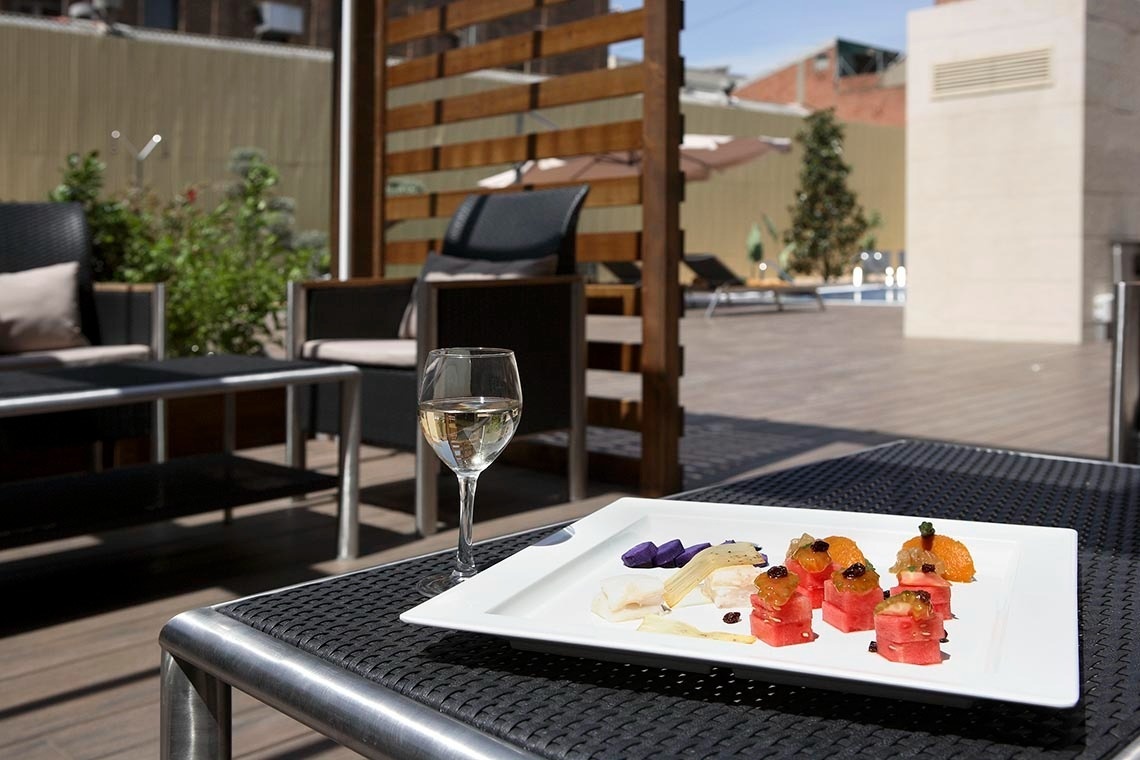 una mesa con un plato de comida y una copa de vino