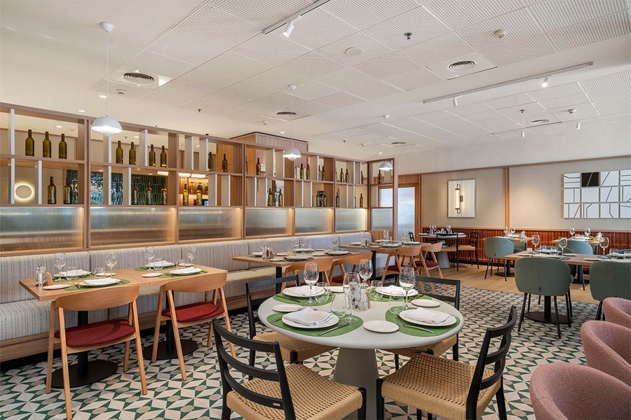 Restaurante moderno en ZT: Villa Olimpica con mesas y sillas elegantes.