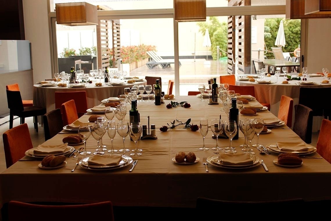 una mesa larga con platos y copas de vino