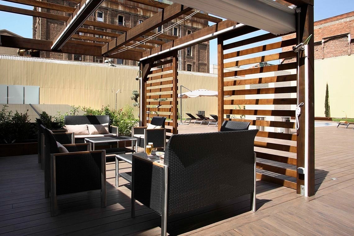 un patio con muebles y una mesa con una cerveza encima