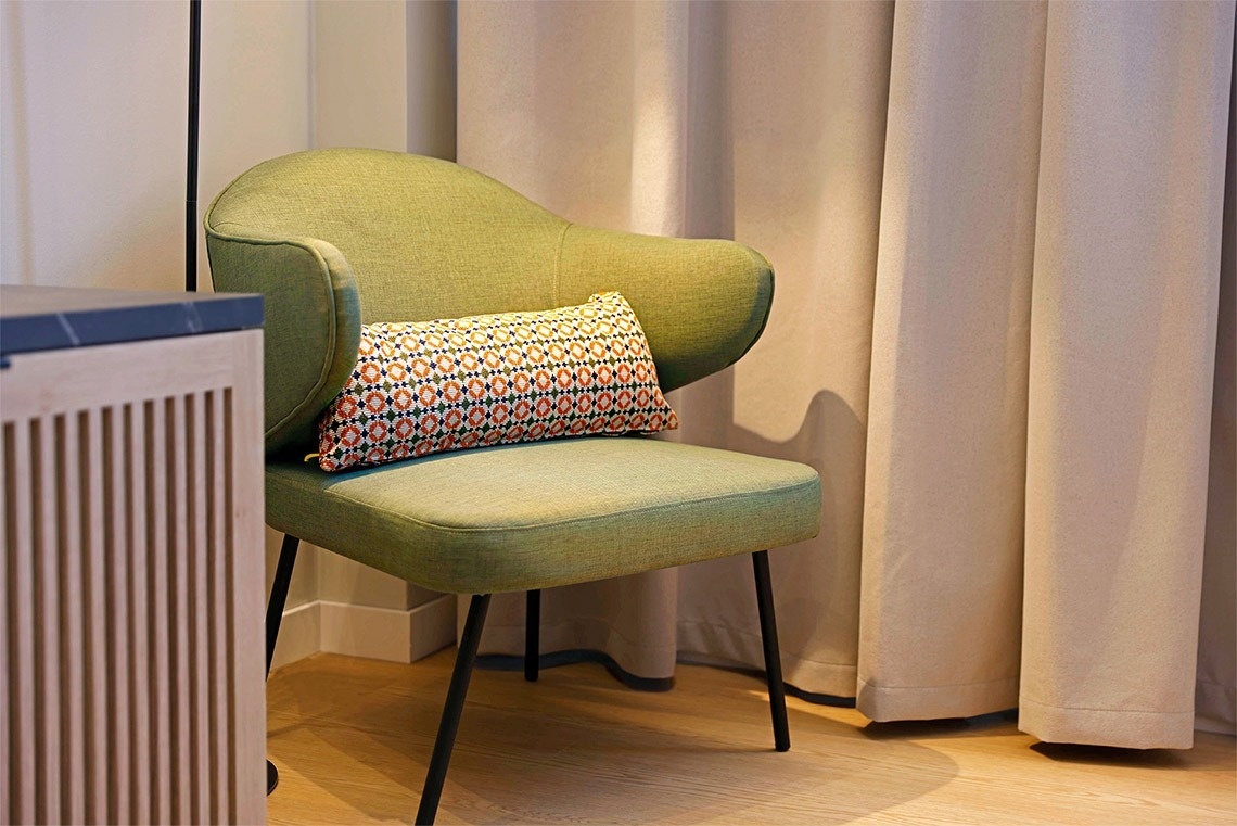 una silla verde con un cojín encima de ella