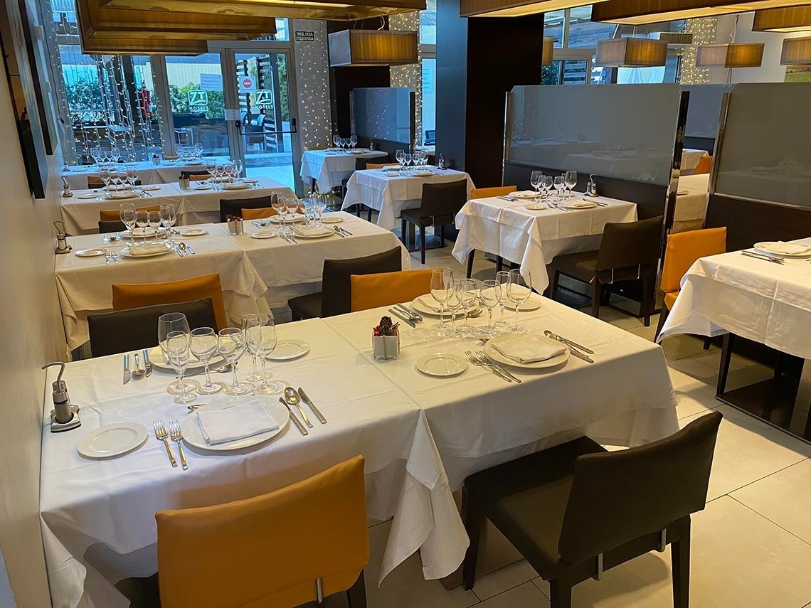 un restaurante lleno de mesas y sillas con platos y copas de vino